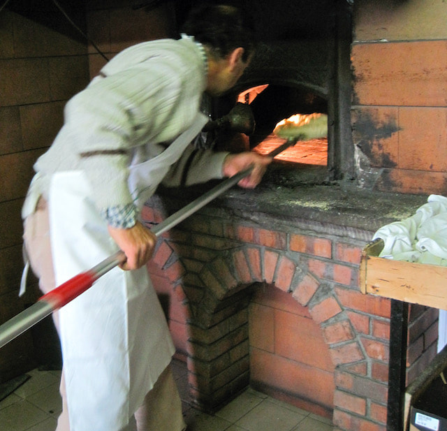 baker at wood-fired oven